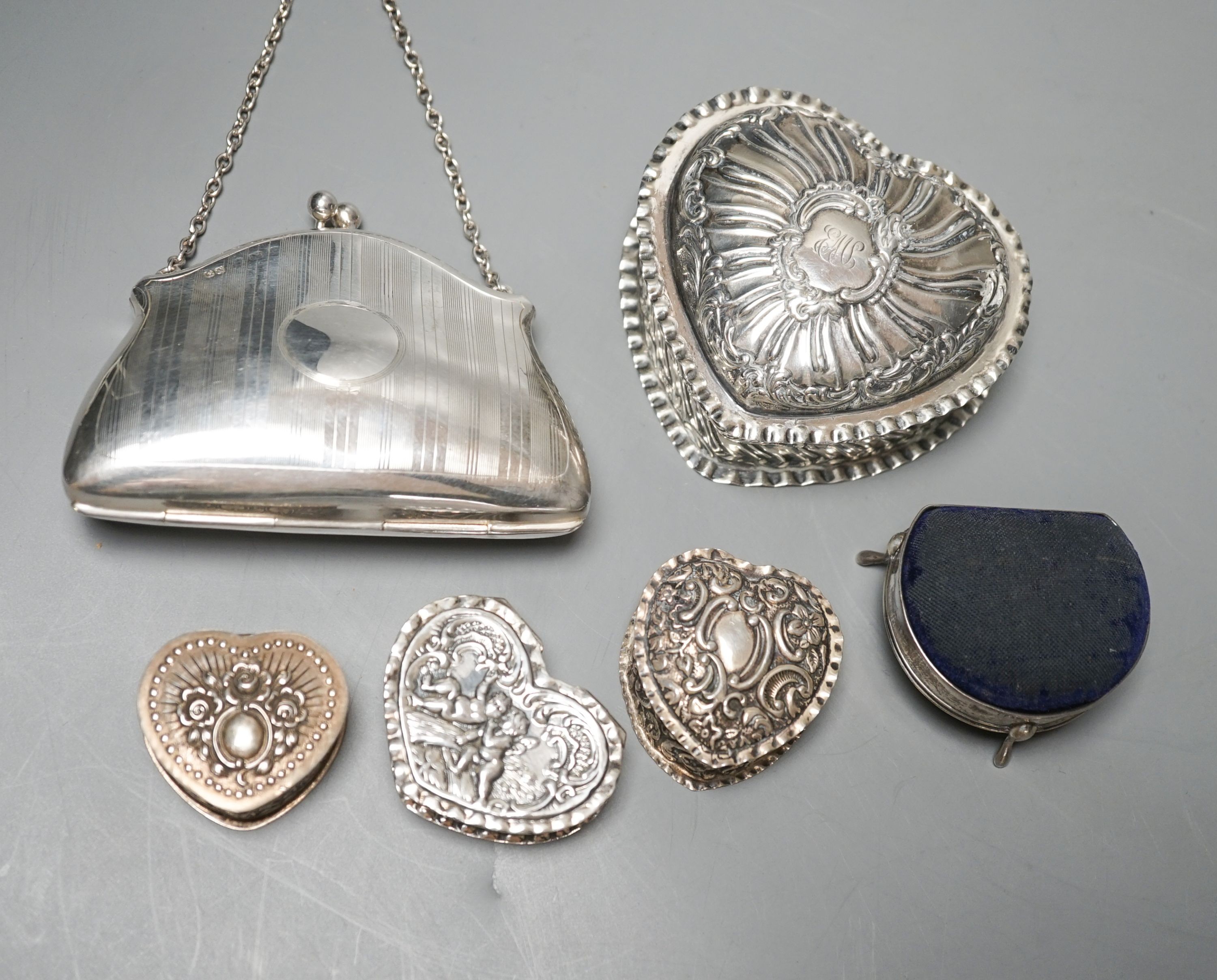 Four assorted silver or white metal heart shaped trinket boxes, largest 85mm a silver pin cushion and a silver purse.